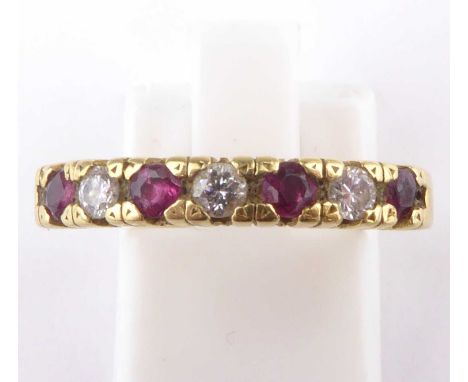 An 18ct gold ruby and diamond half eternity ring, with four claw set rubies, separated with three small brilliant cut diamond