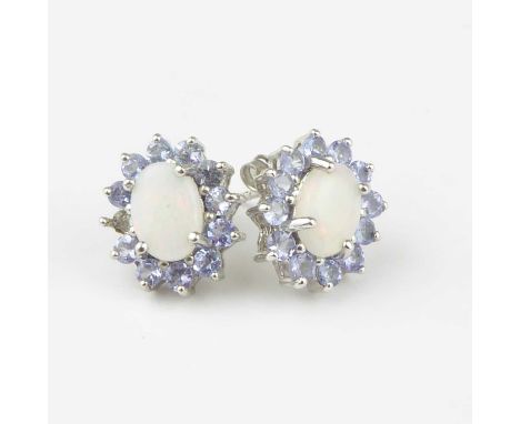 A pair of 9ct white gold opal cluster earrings, the claw set opal cabochon with hints of red and green, in a flower border of