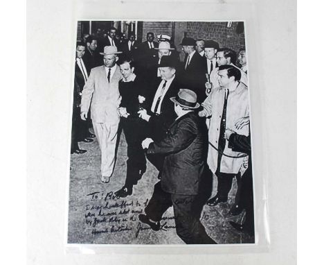 LEE HARVEY OSWALD RELATED; a large reproduced black and white photograph inscribed 'To Bob, I was handcuffed to Lee Harvey Os