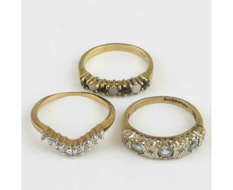 Three 9ct gold dress rings comprising a white stone wishbone example, size N, a pale blue and illusion set diamond chip half-