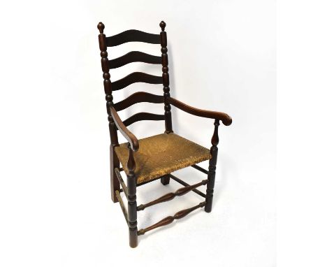 A 19th century country made rush-seated ladder back open arm elbow chair and an oak side chair (2).
