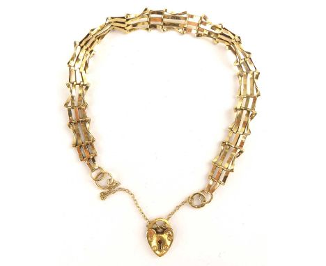 A 9ct gold four bar gate bracelet with 9ct gold heart-shaped padlock clasp and safety chain, length 18cm, approx. 5.1g.