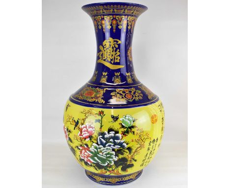 A modern 20th century large floor-standing vase with gilt script, floral panels and patterns to the cobalt blue slender neck,