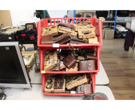 A three tier shelf containing vintage lighters and cases 