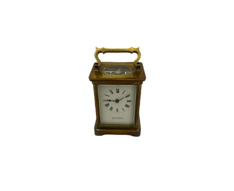 A late 19th century French corniche cased carriage clock , four bevelled glass panels and an oval glass to the top, with a wh