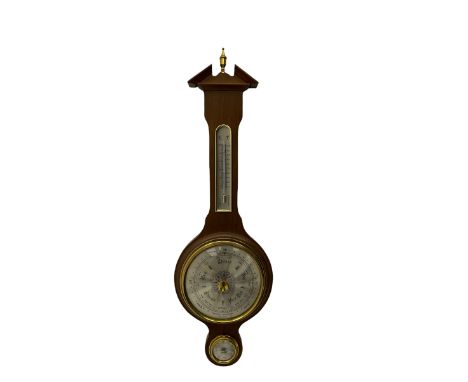 A contemporary German Aneroid barometer in a mahogany effect case with a broken pediment and finial, silvered register measur