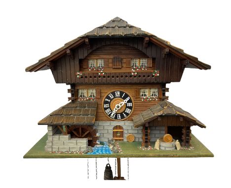 An automaton musical cuckoo clock with a 20th century three weight movement in the form of a Swiss Chalet with a working wate