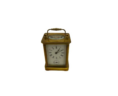 An early 20th century French corniche cased carriage clock with an alarm, four bevelled glass panels and oval glass to the to