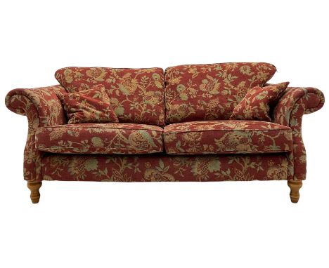 Traditional shape three seat sofa, upholstered in red fabric with trailing floral pattern, on turned front feetDimensions: Le