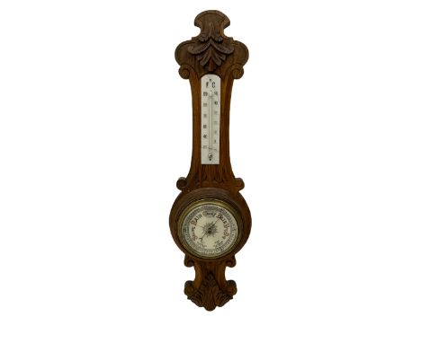 A carved oak cased aneroid barometer with a 5”&nbsp;register, measuring barometric pressure from 26 to 31.9 inches, weather p