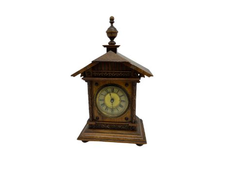 A German musical alarm clock (model 1523/24) made by the Hamburg Amerikanische Uhrenfabrik c1880, in an oak case with an arch