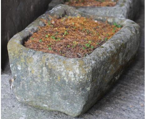 A SANDSTONE TROUGH of rough hewn rounded oblong tapering form, 27 1/2" x 21" x 13" (Est. plus 18% premium inc. VAT)