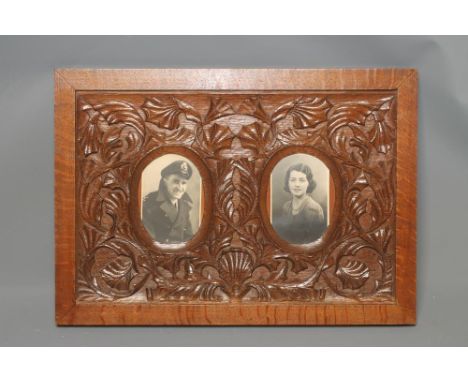 ATTRIBUTED TO ARTHUR SIMPSON OF KENDAL, an Arts and Crafts carved oak double portrait frame, the two oval apertures within a 