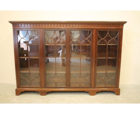 A GLAZED MAHOGANY BOOKCASE, c.1900, the moulded edged top and lambrequin frieze over four astragal glazed doors enclosing adj