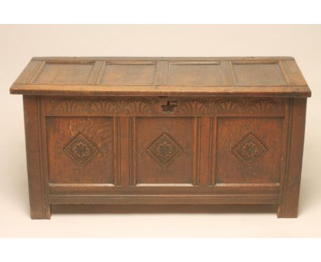 AN OAK PANELLED COFFER, early 18th century, the hinged lid opening to interior with small shelf, three panelled lozenge carve