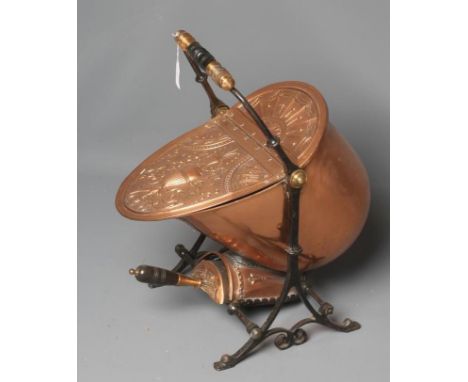 A VICTORIAN COPPER COAL SCUTTLE of helmet form raised on an open scroll work, wrought iron support, the loop handle with ebon