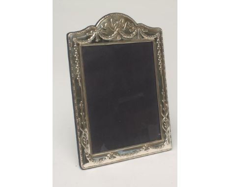 AN EDWARDIAN STYLE SILVER PHOTOGRAPH FRAME, makers Carrs, Sheffield 2010, of easel back vertical arched oblong form, the fasc