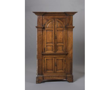 A GEORGIAN ELM STANDING CORNER CUPBOARD of architectural form with inverted breakfront moulded cornice, bold stop fluted pila