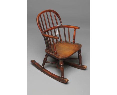 A CHILD'S YEW WOOD WINDSOR ROCKING CHAIR of low hooped stick back form, slender baluster turned arm supports, elm seat, on ba