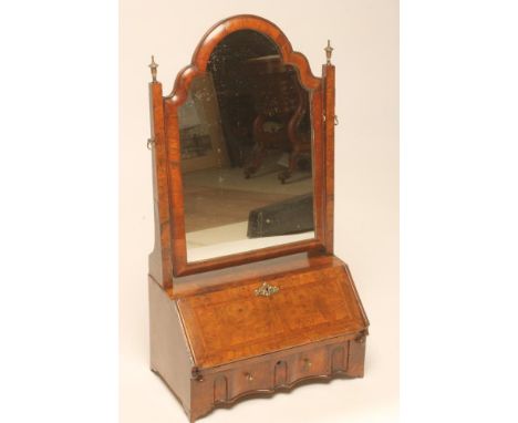 AN EARLY GEORGIAN AND LATER WALNUT TOILET MIRROR, the arched oblong plate within a cushion moulded frame and suspended from s