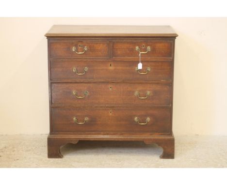A GEORGIAN OAK CHEST, late 18th century, the moulded edged top and plain frieze over two short and three long drawers with br