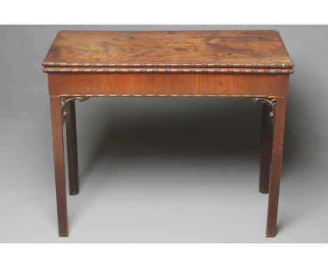 A GEORGIAN MAHOGANY FOLDING CARD TABLE, c.1760, of oblong form, the carved ovolo edged top opening on to a concertina action 