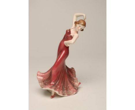 AN ART DECO KATZHUTTE EARTHENWARE FIGURE of a young lady dancer wearing a shaded dusky pink sleeveless dress, in a flamboyant