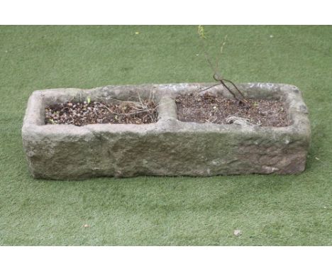 A SANDSTONE TROUGH of rough hewn oblong form with central division, 40 1/2" x 13 1/2" x 9 1/2" (Est. plus 18% premium inc. VA