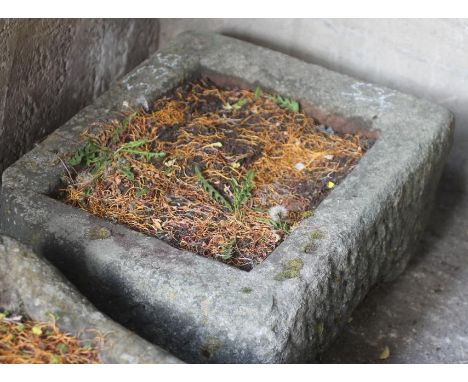 A SANDSTONE TROUGH of rough hewn oblong form with one rounded corner, 24" x 21" x 11 1/2" (Est. plus 18% premium inc. VAT)