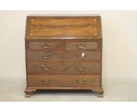 A GEORGIAN MAHOGANY BUREAU, c.1800, the banded fallfront with veneered panel and marquetry batwing cut corners, fitted interi