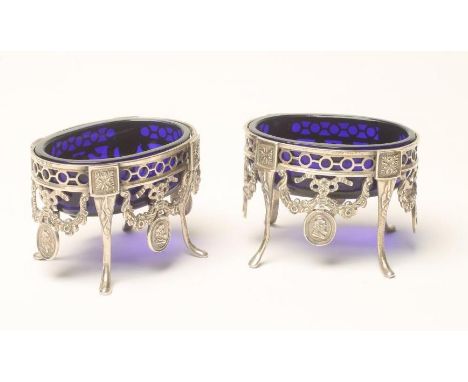 A PAIR OF EARLY VICTORIAN SILVER SALTS, maker possibly G.F. Pinnell, London 1846, of oval form, the spectacle pierced rim sup