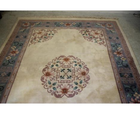 A CHINESE WASHED AND FRINGED CARPET, modern, the ivory field with central stylised floral roundel and matching spandrels, sil