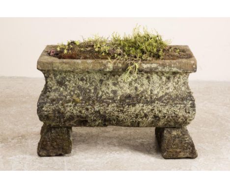A SANDSTONE TROUGH of oblong form with ogee sides and cut corner well, raised on splayed oblong supports, 34 1/2" x 17 1/2" x