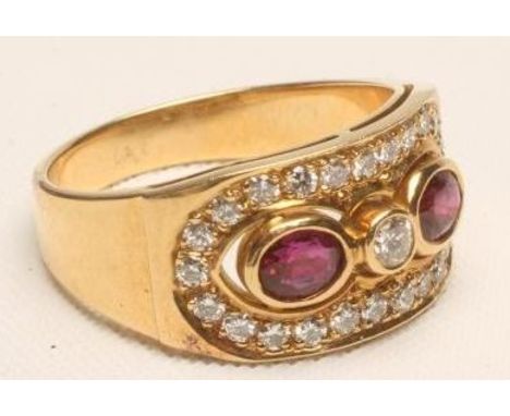 A RUBY AND DIAMOND DRESS RING, the oblong panel centred by a round brilliant cut diamond flanked by an oval ruby to each side