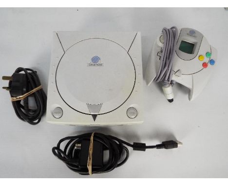 Sega - A Dreamcast console with power lead and controller. The items are dusty from storage and would benefit from cleaning, 