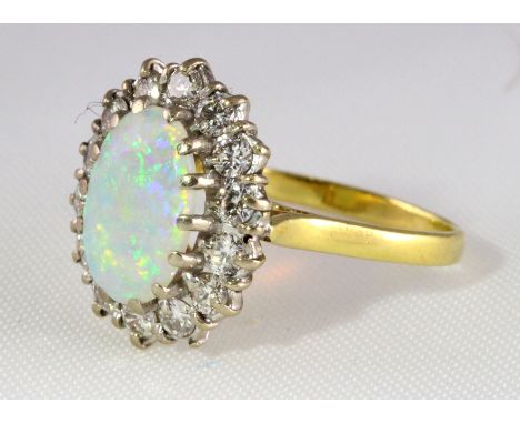 An 18ct H/M oval opal and diamond cluster ring, approx total diamond weight 0.70ct, size P