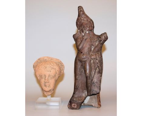 Terrakottastatuette des Harpokrates, römisch, 1.- 2.Jh. &amp;amp; Votivkopf, Terrakotta, römisch, wohl 1. Jh.Stehender Harpok