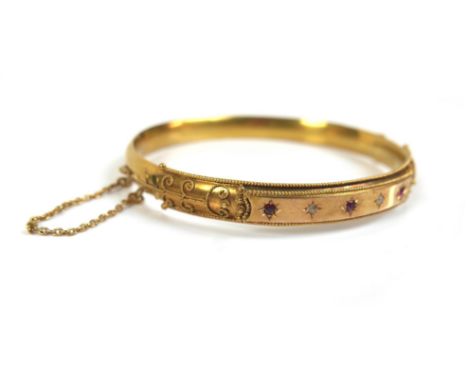 A Victorian 15ct yellow gold, ruby and diamond hinged bangle, set with two small diamonds and three rubies, each 2.0mm, in st