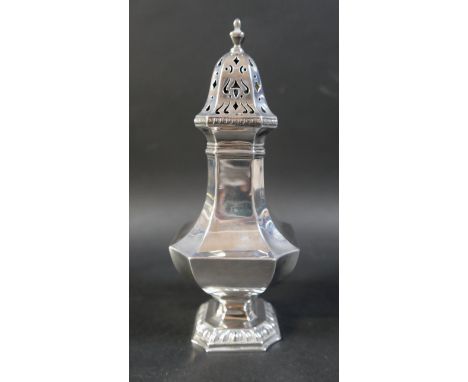 A George V silver sugar caster, the removable cover pierced with scrolls, urn shaped finial, the body of squared baluster for