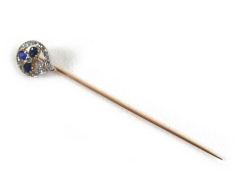 A Victorian gold, sapphire and diamond stick pin, in the form of a flower with three sapphire leaves, each 3.5mm long, encirc