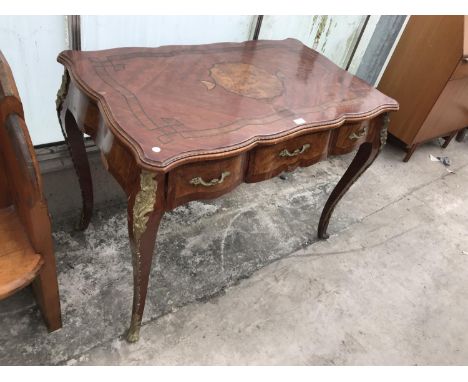 A DECORATIVE INLAID MAHOGANY TABLE WITH THREE DRAWERS AND ORNATE GILDED DECORATION 