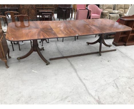 A LARGE MAHOGANY DINING TABLE ON TWIN PEDESTAL SUPPORTS WITH BRASS LIONS PAW FEET AND TWO EXTRA LEAVES 