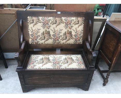 AN OAK MONK'S BENCH WITH TAPESTRY SEAT AND BACK AND STORAGE COMPARTMENT SEAT (CONVERTS TO A TABLE) 