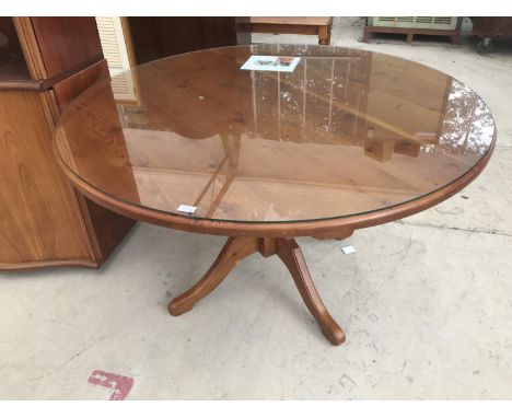 A CIRCULAR OREGAN PINE DINING TABLE WITH GLASS TOP 