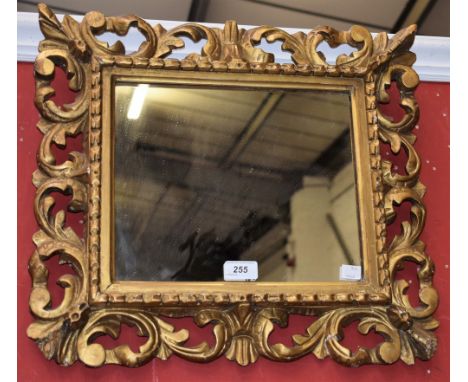 A 19th century gilt gesso and softwood shaped rectangular looking-glass, mirror plate, the frame with acanthus to angles and 