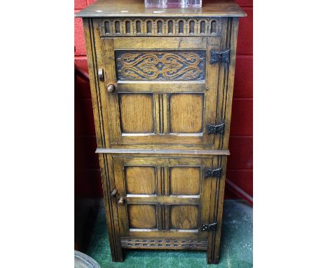 A 20th century oak side cabinet, oversailing top above two panel doors, each enclosing a shelf, stile feet, 124cm high