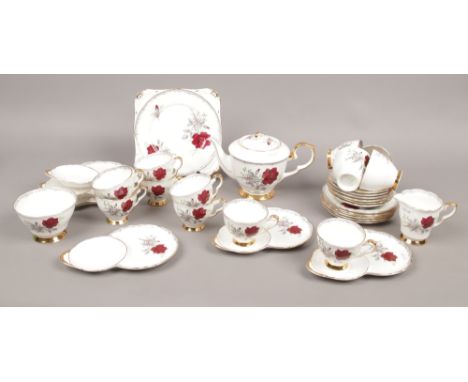 A Royal Stafford bone china tea set decorated in the Roses to Remember pattern to include tennis cup and saucers