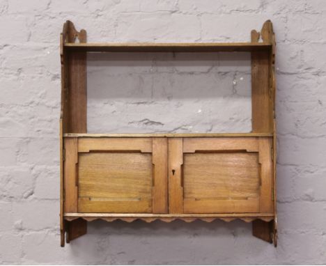 A light oak single shelf wall cabinet with fretwork decoration.