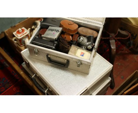 Three aluminium flight cases, one containing vintage photographic equipment, mainly light meters, a Rollei boxed filter ring 