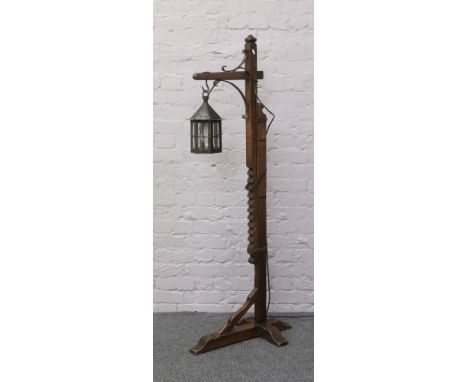 An oak Arts and Crafts rise and fall Hangman standard lamp with clasp and metal lantern shade.